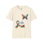 Natural t-shirt featuring a colorful butterfly and multicolored puzzle ribbon design with the word “Autism,” representing autism awareness and inclusion.
