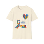 Natural t-shirt featuring a colorful heart made of puzzle pieces and a multicolored puzzle ribbon with the word “Autism,” symbolizing autism awareness, love, and inclusion.