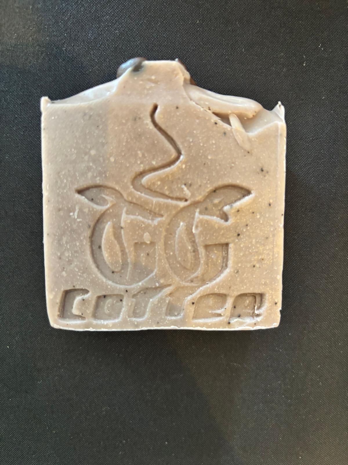 GG Coffee Soap bar featuring a natural exfoliant texture and logo on a dark background.